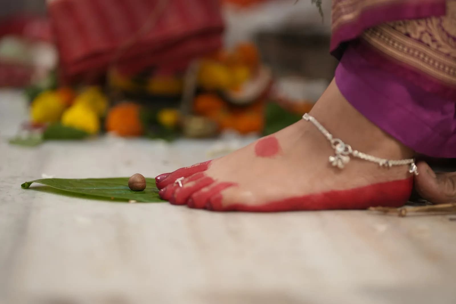 Charm Kundan Anklet - A bride's foot with anklet, painted red for a ceremony