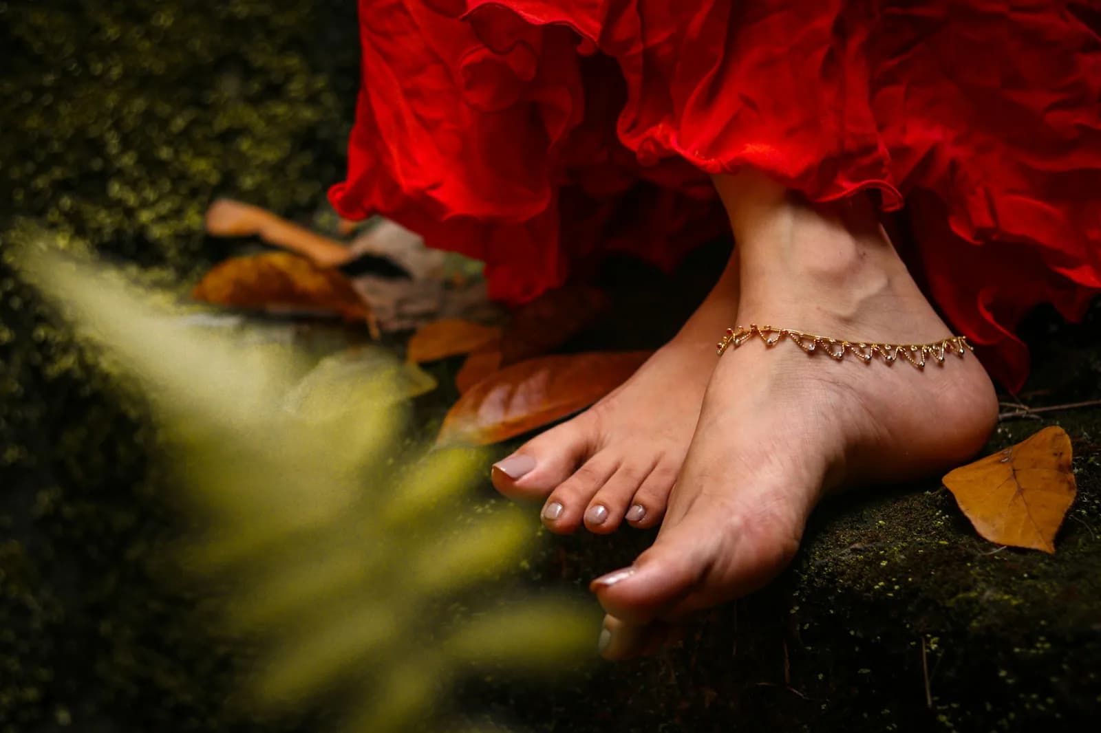 Charm Kundan Anklet - Person wearing gold anklet and red dress
