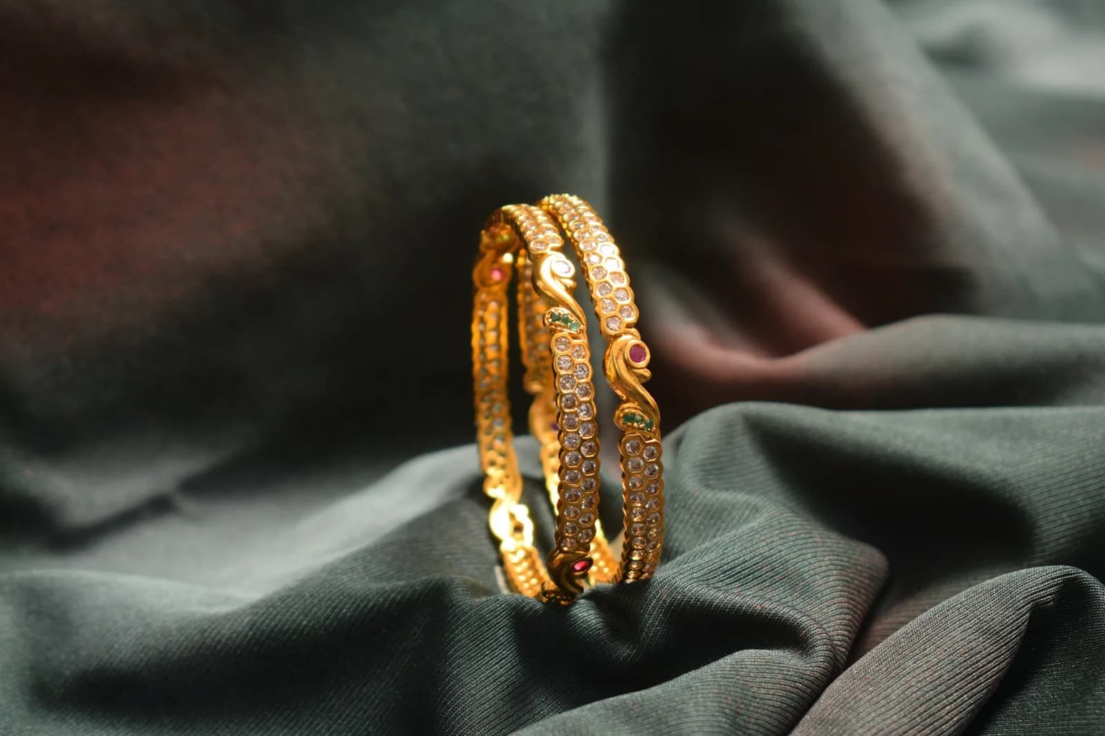 Charm Antique Gold Bangle - A close up of a gold bracelet on a cloth