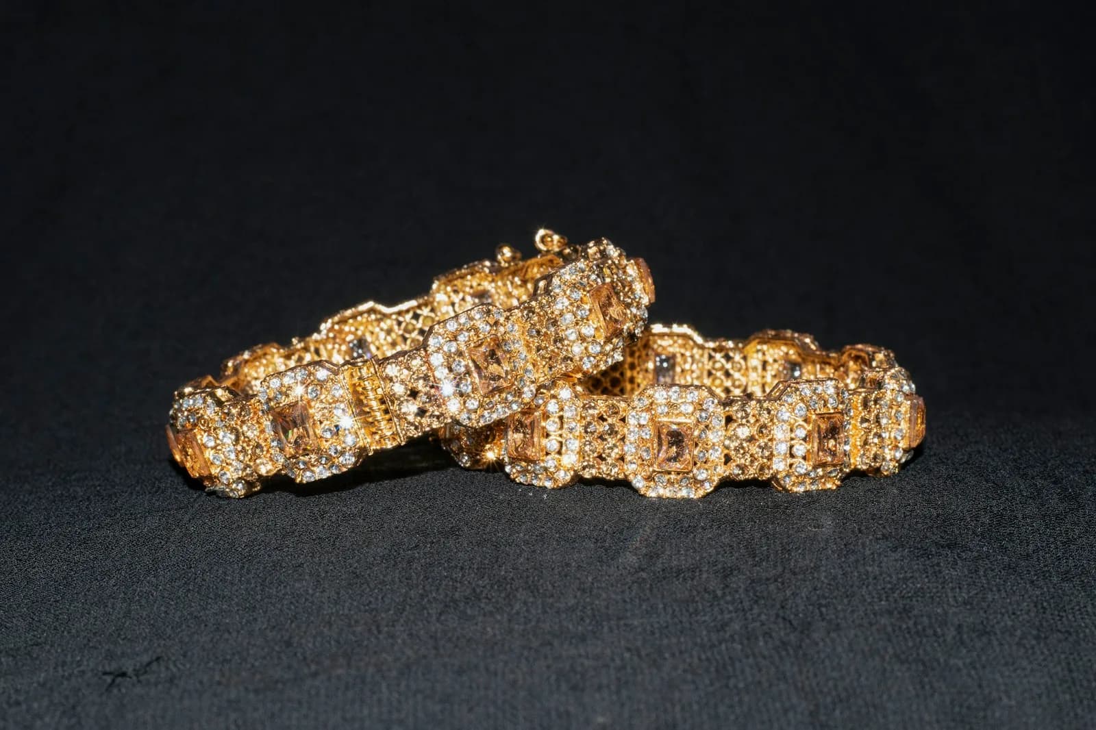 Nakshi Rose Gold Bangle - A couple of gold bracelets sitting on top of a table