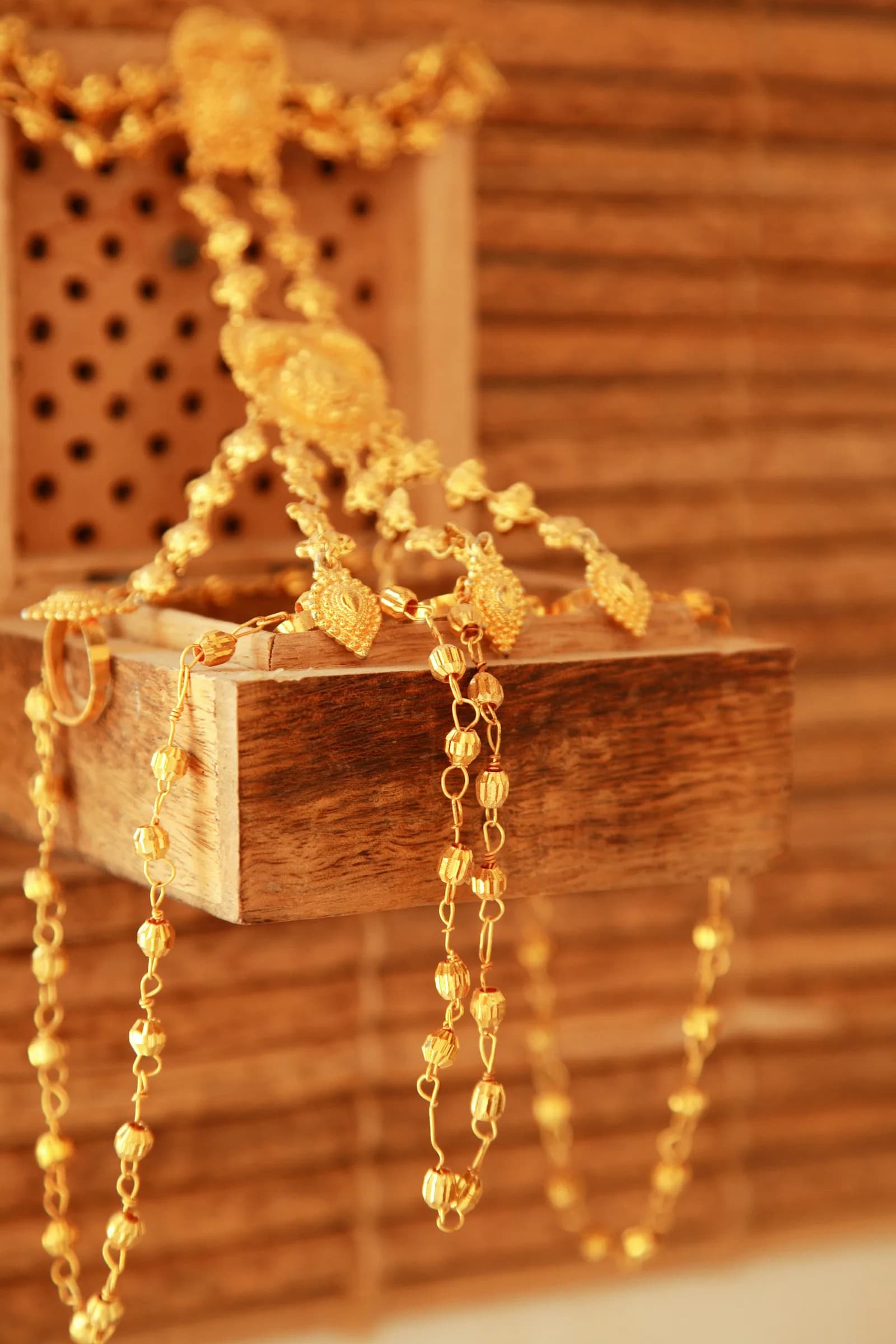 Diamond Kundan Mangalsutra - Gold and white beaded necklace on brown wooden box