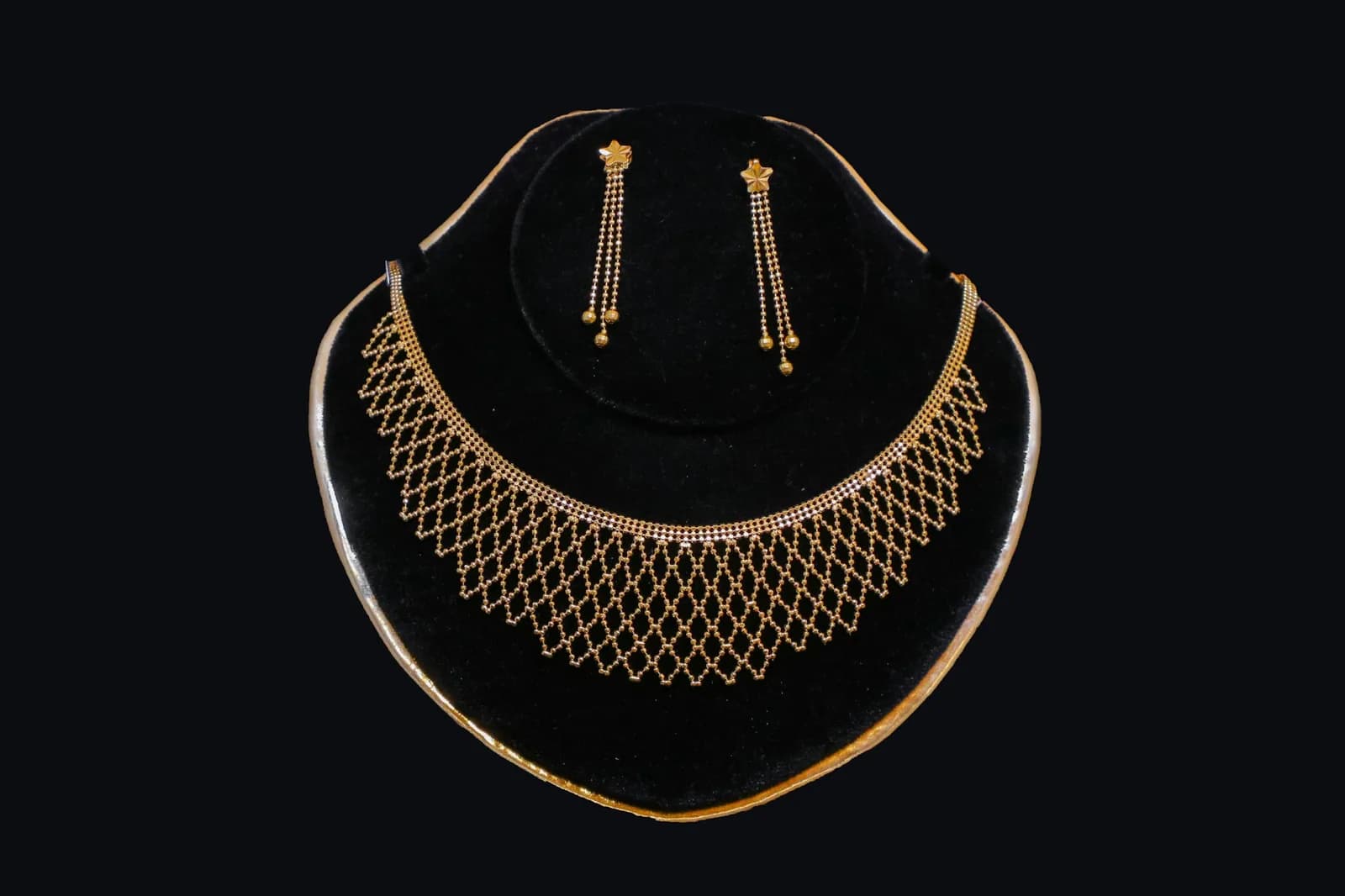 Meenakari Antique Gold Necklace - Gold necklace and earrings displayed on black velvet